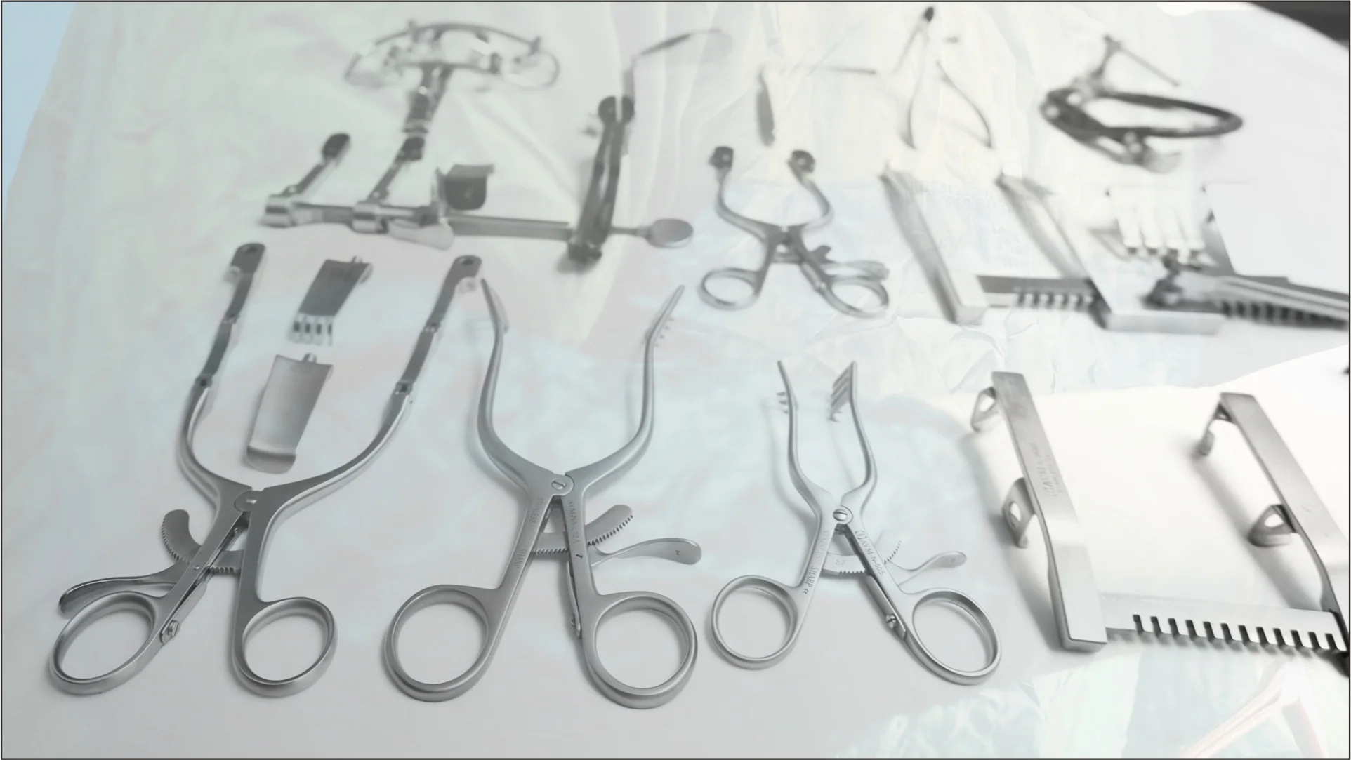 Precision surgical instruments laid out on a green drape in an operating room